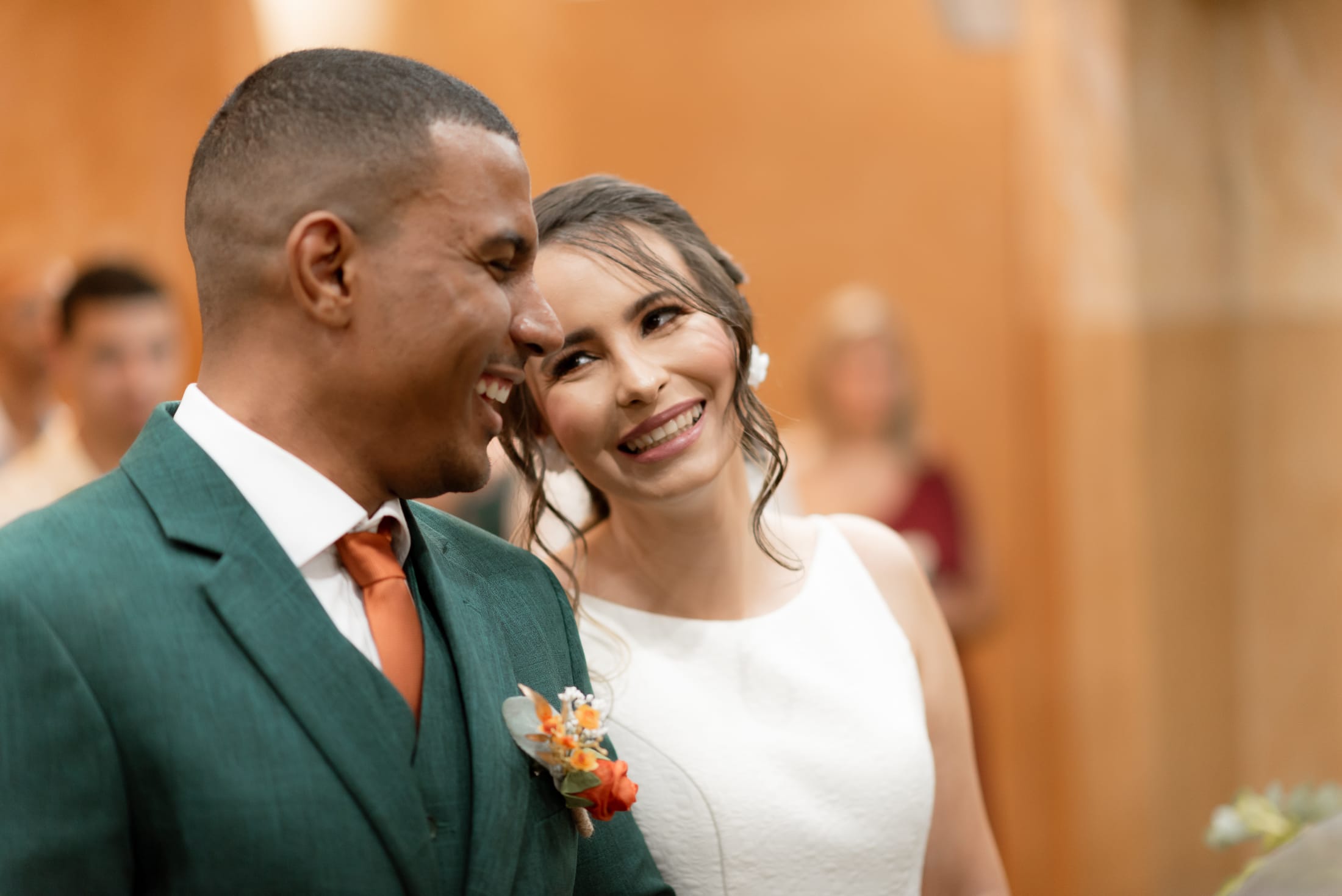 Aline sorrindo ao lado de Leonardo no altar, terno verde e gravata terracota